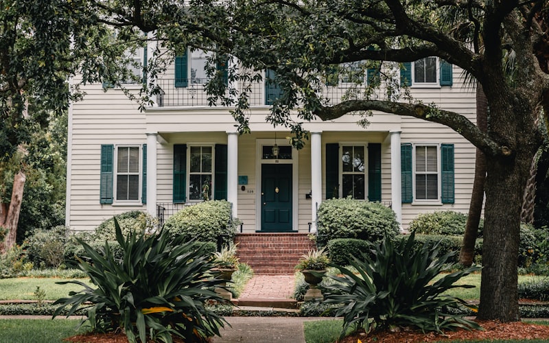 Beautiful white home with new windows surrounded by green trees